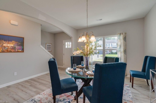 dining space featuring a notable chandelier and light hardwood / wood-style floors