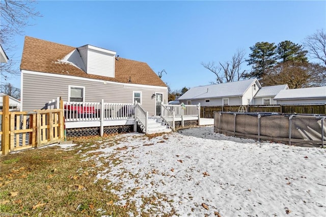 rear view of property featuring a pool side deck