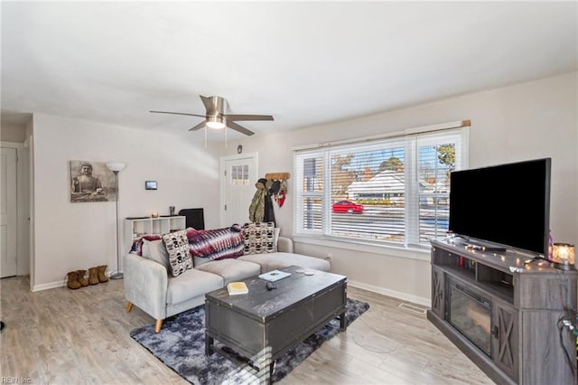 living room featuring ceiling fan and light hardwood / wood-style flooring