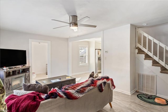 living room featuring light hardwood / wood-style flooring and ceiling fan