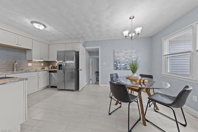 dining room with sink and an inviting chandelier