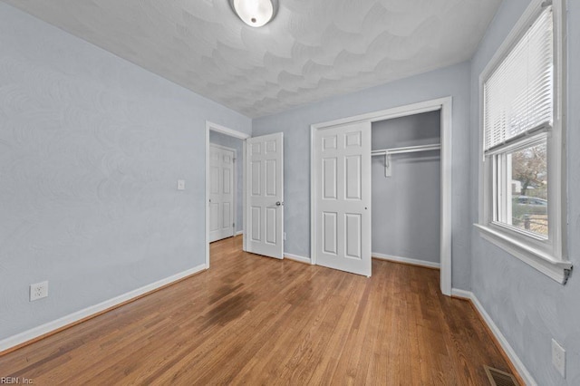 unfurnished bedroom with a closet and light hardwood / wood-style flooring