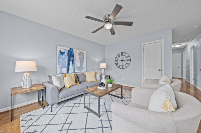 living room featuring ceiling fan and light hardwood / wood-style flooring