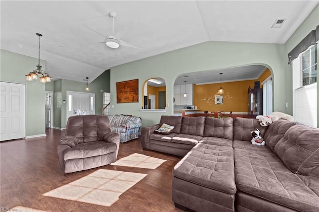 living room featuring ceiling fan with notable chandelier, dark hardwood / wood-style floors, a healthy amount of sunlight, and vaulted ceiling