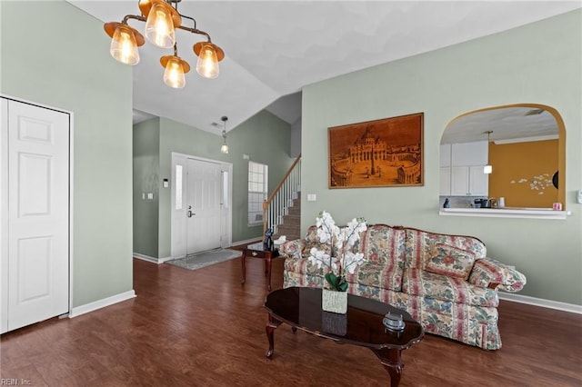 living room with dark hardwood / wood-style floors, vaulted ceiling, and a notable chandelier