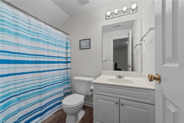 bathroom with hardwood / wood-style floors, lofted ceiling, vanity, toilet, and walk in shower