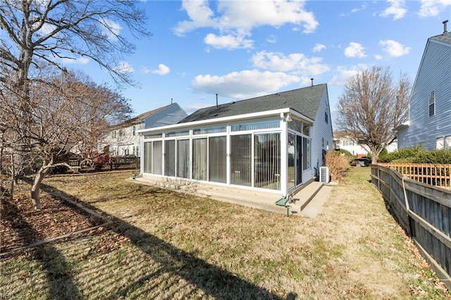 rear view of house with a lawn and a sunroom