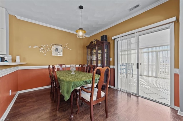 dining room featuring crown molding and dark hardwood / wood-style flooring