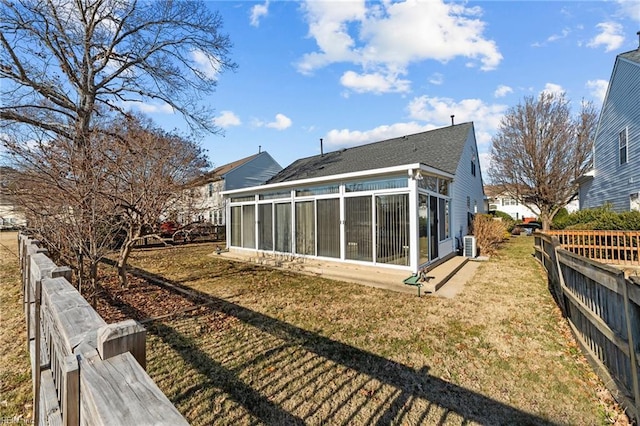 back of house with a yard and a sunroom