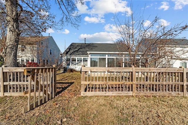 rear view of property featuring a wooden deck and a yard