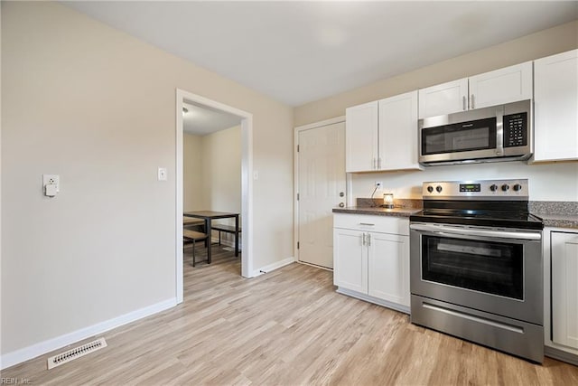 kitchen featuring white cabinets, light hardwood / wood-style flooring, and stainless steel appliances