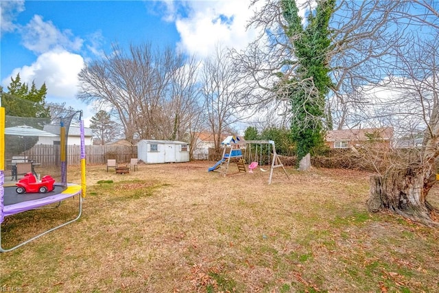 view of yard with a playground, a trampoline, and a shed