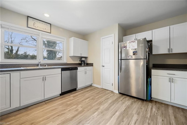 kitchen featuring sink, light wood-type flooring, white cabinetry, and stainless steel appliances