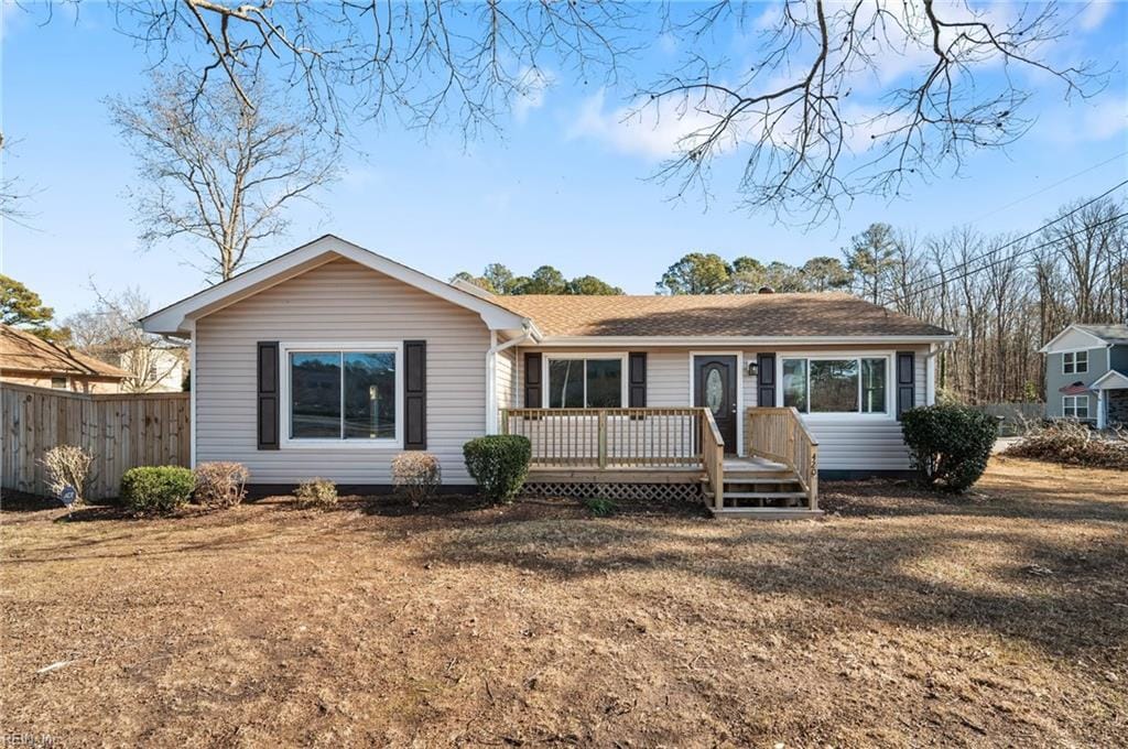 ranch-style house with a deck and a front yard