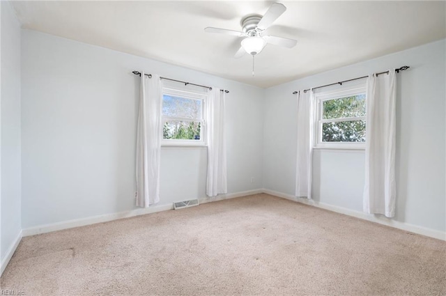 carpeted spare room with ceiling fan