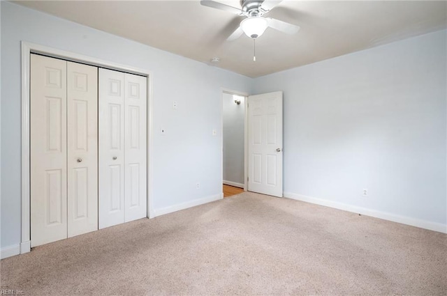 unfurnished bedroom featuring light colored carpet, ceiling fan, and a closet