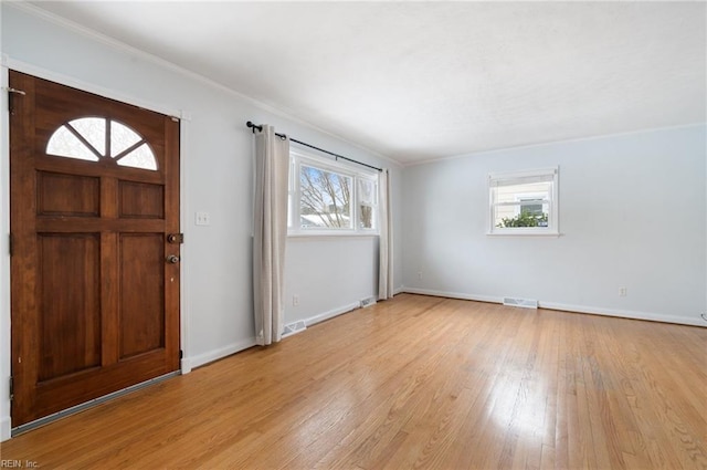 foyer featuring crown molding and light hardwood / wood-style floors