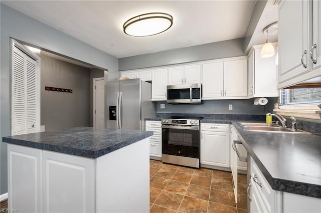 kitchen featuring hanging light fixtures, white cabinetry, appliances with stainless steel finishes, and a kitchen island