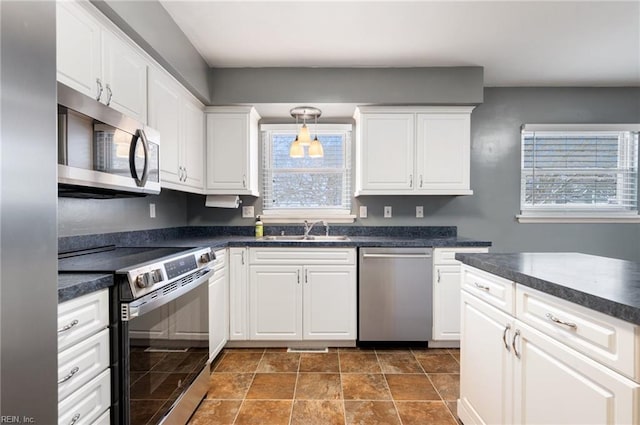 kitchen featuring white cabinetry, sink, a wealth of natural light, and appliances with stainless steel finishes