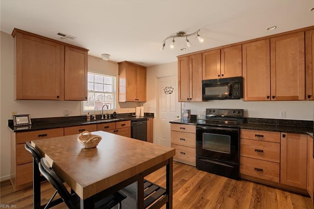 kitchen featuring sink, black appliances, and light hardwood / wood-style floors