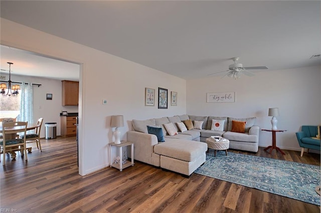 living room featuring dark hardwood / wood-style floors and ceiling fan with notable chandelier