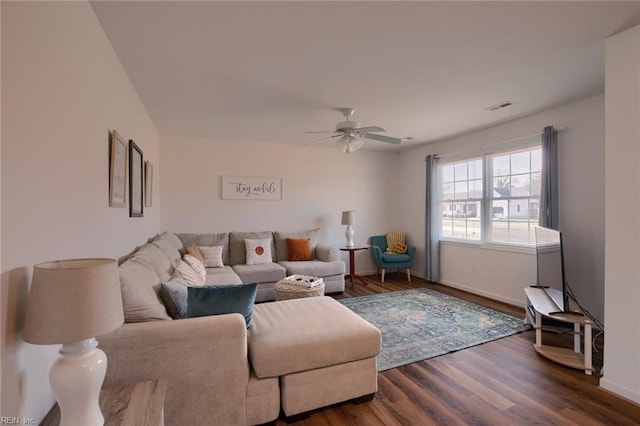 living room featuring ceiling fan and dark hardwood / wood-style flooring