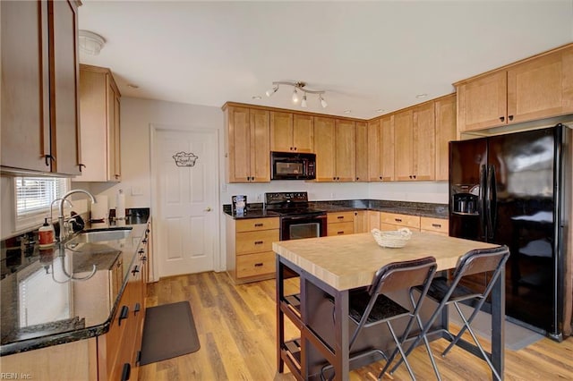 kitchen with sink, light brown cabinetry, light wood-type flooring, and black appliances