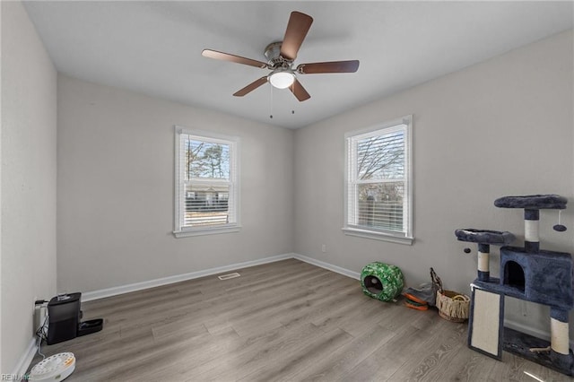 interior space with ceiling fan, a healthy amount of sunlight, and light wood-type flooring