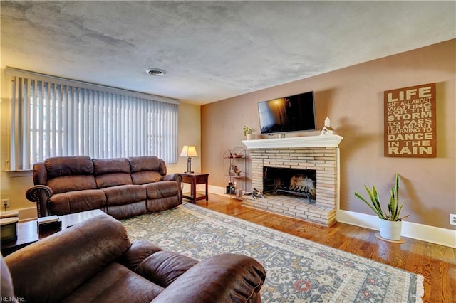 living room featuring hardwood / wood-style floors and a brick fireplace