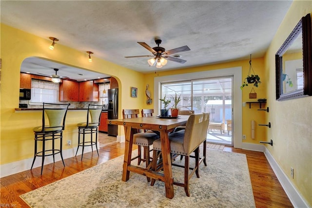 dining room with ceiling fan and light hardwood / wood-style floors