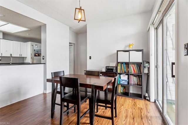 dining room featuring sink, a wealth of natural light, and light wood-type flooring