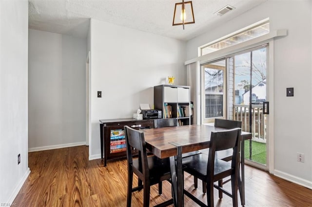 dining area featuring light hardwood / wood-style floors and a textured ceiling