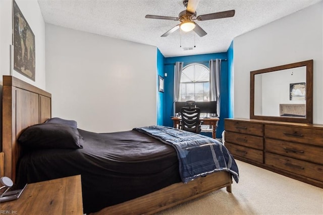 carpeted bedroom with ceiling fan and a textured ceiling