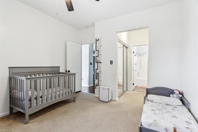 bedroom with ceiling fan, ensuite bath, and light carpet