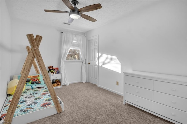 unfurnished bedroom featuring ceiling fan, light colored carpet, and a textured ceiling