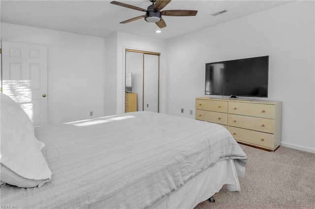 carpeted bedroom with ceiling fan and a closet