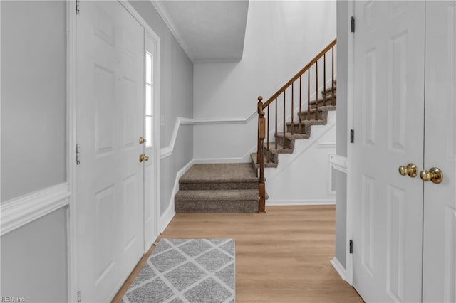 entryway featuring ornamental molding and light hardwood / wood-style floors