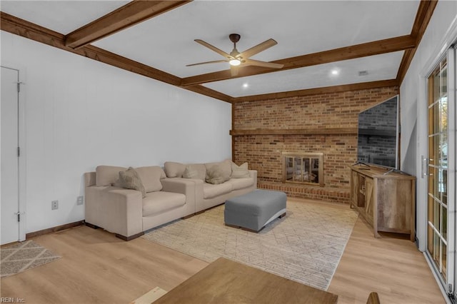 living room with ceiling fan, a fireplace, beam ceiling, and light hardwood / wood-style flooring