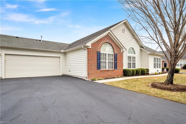 ranch-style home with a garage and a front lawn