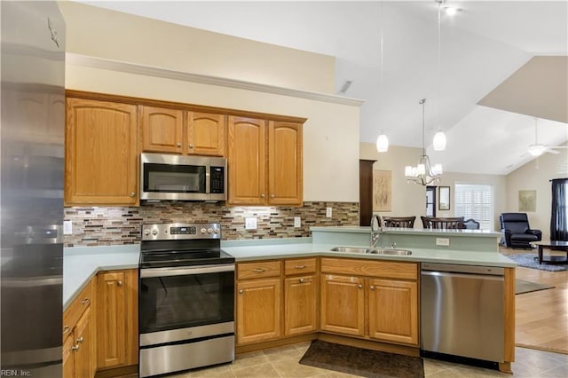 kitchen with sink, tasteful backsplash, lofted ceiling, and stainless steel appliances