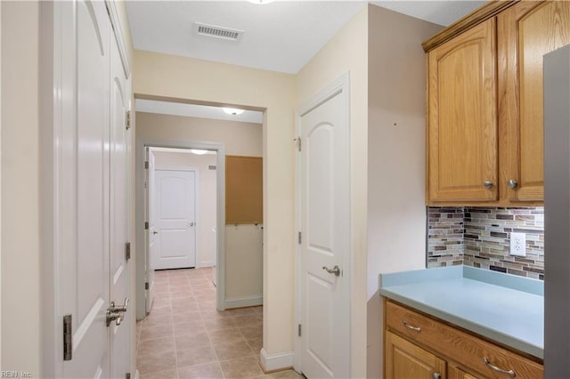 interior space with backsplash and tile patterned flooring