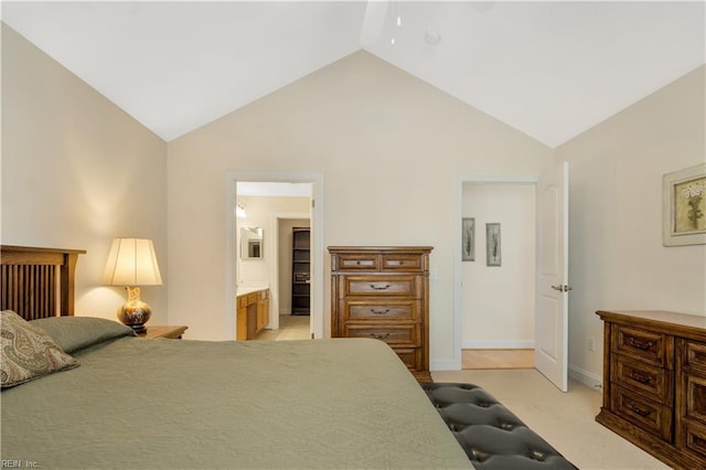 carpeted bedroom featuring vaulted ceiling and ensuite bath