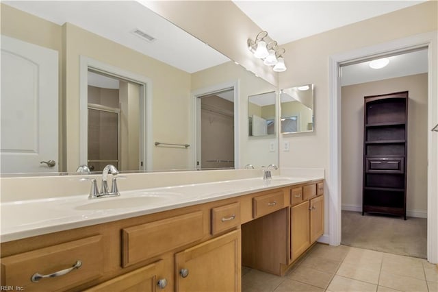 bathroom featuring tile patterned flooring, an enclosed shower, and vanity