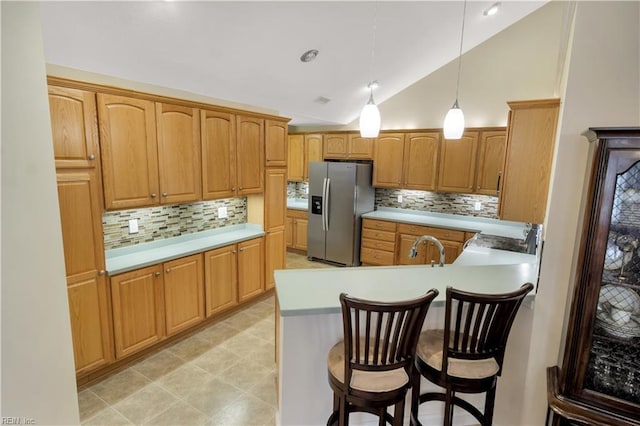 kitchen with hanging light fixtures, decorative backsplash, stainless steel refrigerator with ice dispenser, and lofted ceiling