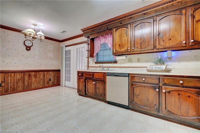 kitchen featuring stainless steel dishwasher, french doors, sink, ornamental molding, and a chandelier