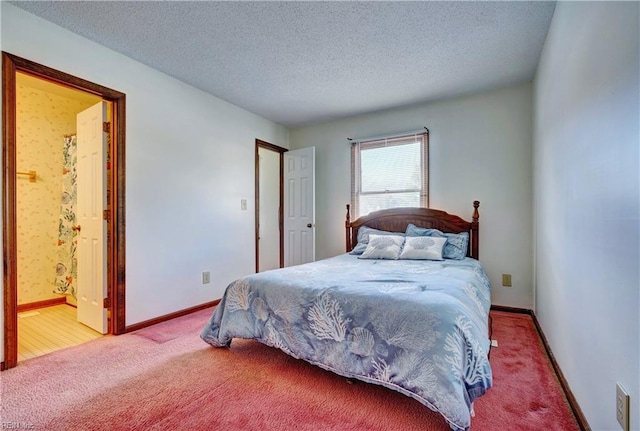 bedroom featuring carpet, connected bathroom, and a textured ceiling