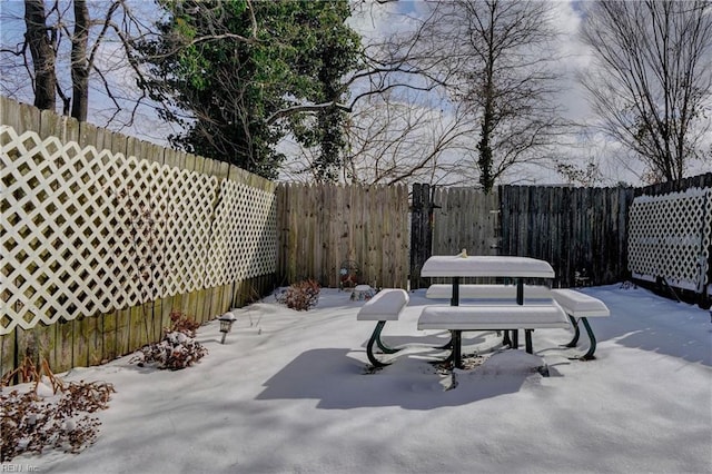 yard layered in snow featuring a patio