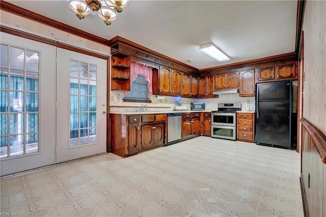 kitchen with appliances with stainless steel finishes, tasteful backsplash, sink, ornamental molding, and a notable chandelier