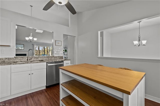 kitchen featuring decorative light fixtures, white cabinetry, sink, stainless steel dishwasher, and light stone countertops