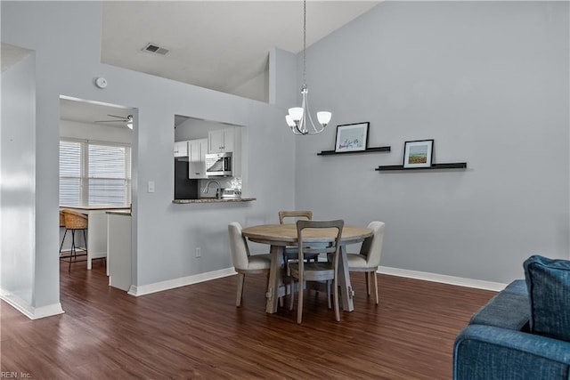 dining room featuring lofted ceiling, dark hardwood / wood-style floors, and ceiling fan with notable chandelier